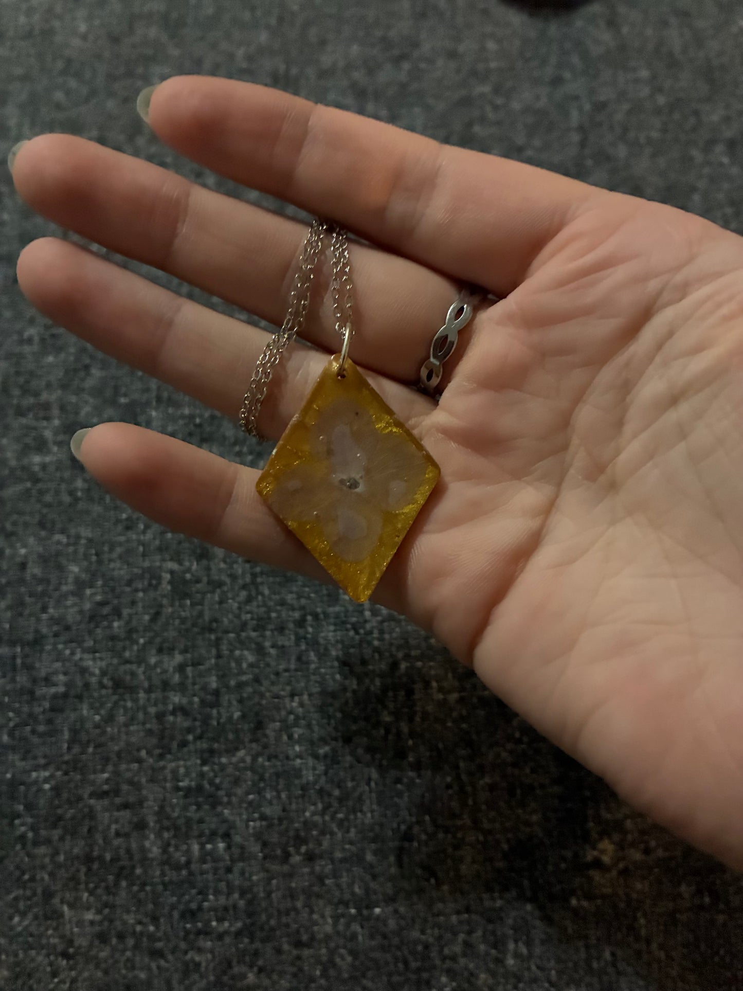 Purple flower on gold pendant