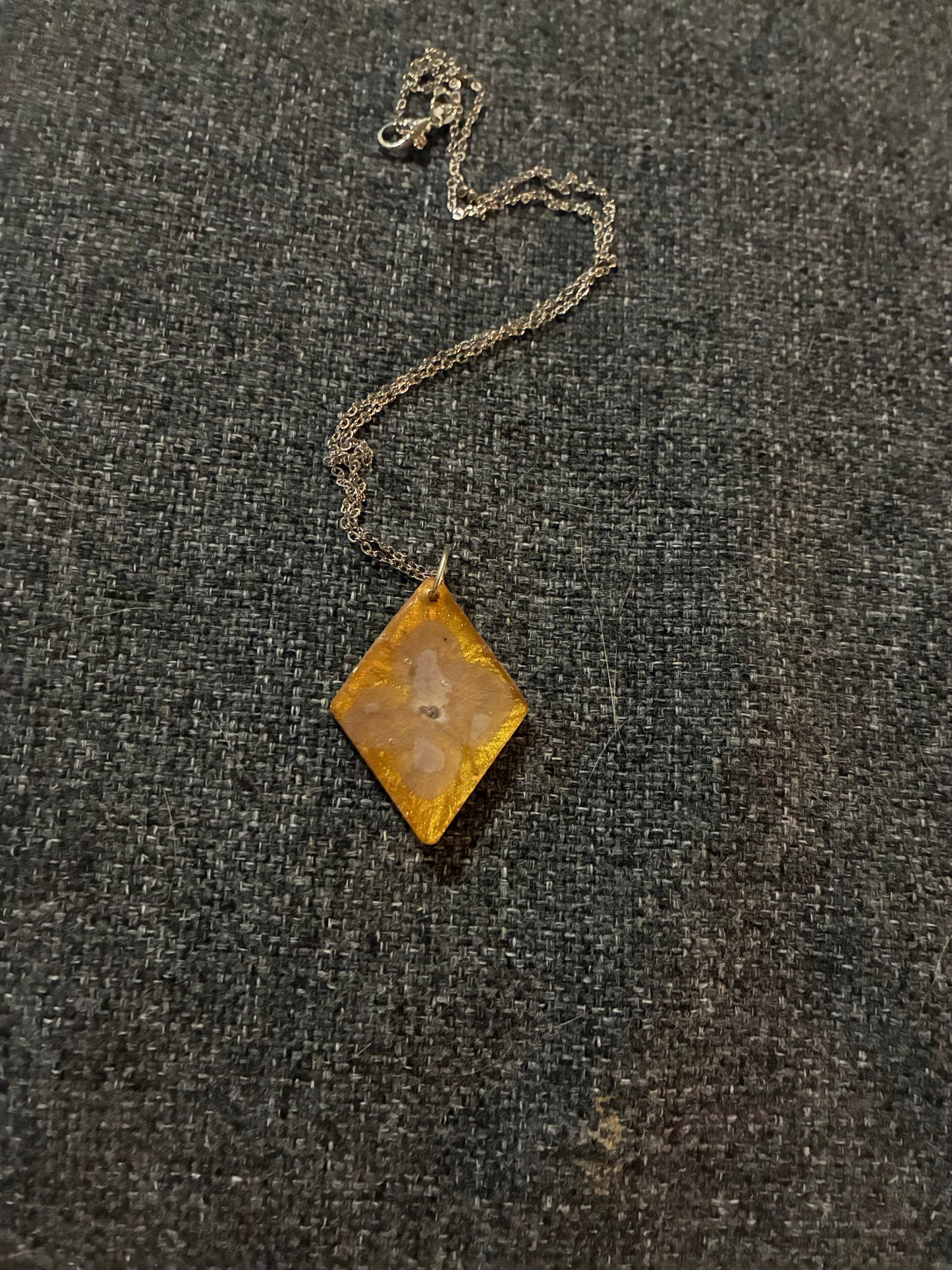 Purple flower on gold pendant